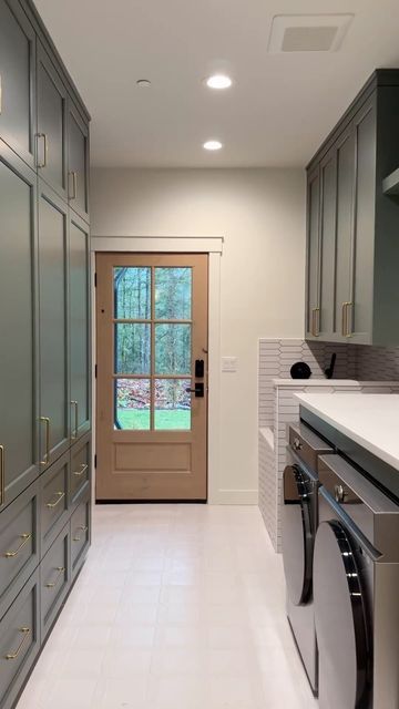 ᴏᴀᴋ ʜᴇᴀʀᴛʜ ʜᴏᴍᴇs on Instagram: "Is this still laundry room goals for 2024?!? 😍😍  This is the laundry/mud room that you need in your home!! We are in love with how this room turned out.. and we received so much overwhelming love and support on it too!! You guys love the cabinet color which is “Rosemary” from @sherwinwilliams and the custom dog shower was easily everyone’s favorite i when it comes to remodeling in 2024, your laundry and mud room are in the top 3 of rooms to remodel!  What do you think of this amazing room? Would you want this in your home? Let us know 🙌🏼  If you are looking to renovate your kitchen this year or any space in your home, send us a DM or an email and we can help you design and build the project of your dreams! From kitchen remodels to bathroom remodels and a Mud Room With Dog Bath And Laundry, Bathtub In Laundry Room, Laundry Room Bump Out Addition, Mud Room And Bathroom Combo, Laundry Room With Door To Outside, Farmhouse Laundry Room With Dog Wash, Galley Style Laundry Room, Large Utility Room Ideas Layout, Long Narrow Laundry Room Layout