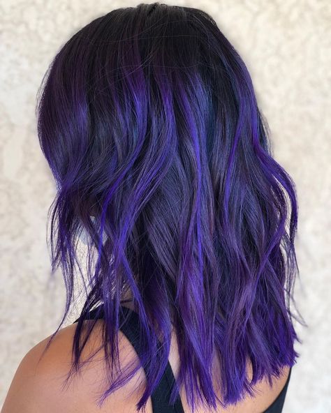 Natural brunettes are guaranteed to love this blue and purple hair. The dark roots can keep the color's vibrancy for a long time. Even without frequent salon visits, the grow-out will still look graceful. Go fun and wild with your chosen hair color. Find a variety of blue and purple hair trends on our website now! #blueandpurplehair #purpleandbluehair Dark Roots With Purple Hair, Fun Hair Color Ideas Black Women, Purple With Dark Roots, Black Blue Purple Hair, Blue Purple Black Hair, Blue Hair With Dark Roots, Purple Hair Ideas For Brunettes, Purple Hair Dark Roots, Black Roots Purple Hair