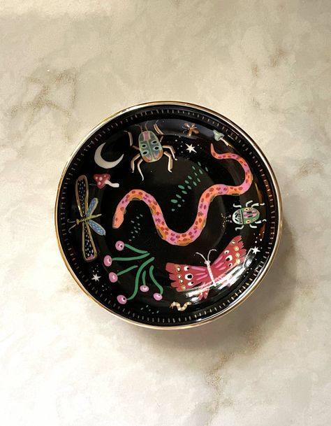 Our ceramic trinket dishes are the perfect catchall for your nightstand or dresser. White ceramic is adorned with our colorful, hand-painted designs, and we lined the edge in metallic gold for added flair. Perfectly packaged in plastic-free gift boxes, pretty enough to give without wrapping! • 3.75″ ROUND DISH • CERAMIC WITH GOLD DETAILING • PLASTIC-FREE GIFT BOX Ceramic Trinket Dish, Dresser White, Color Me Mine, Dish Ceramic, Midnight Garden, Hand Painted Pottery, Mini Frames, Diy Pottery, Ornament Frame