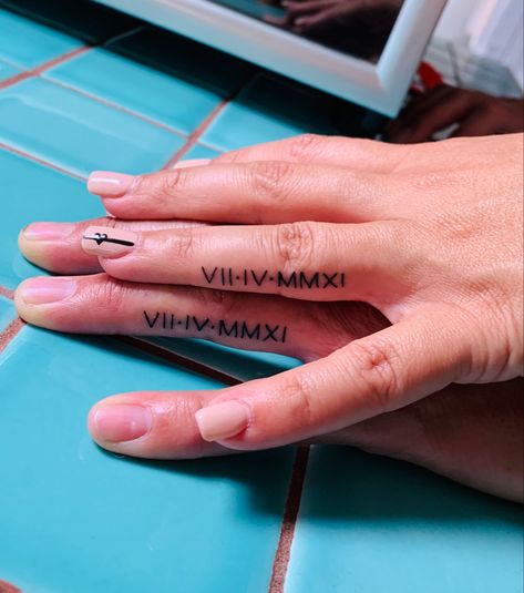 Roman numeral anniverary finger tattoo Coordinates Tattoo Finger, Roman Numeral Finger Tattoo Wedding Ring, Ring Finger Roman Numeral Tattoo, Finger Tattoo Roman Numerals, Roman Numeral Tattoo Ring Finger, Hand Tattoo For Couples, Roman Numeral Tattoo On Finger, Finger Roman Numeral Tattoo, Roman Numerals Finger Tattoo