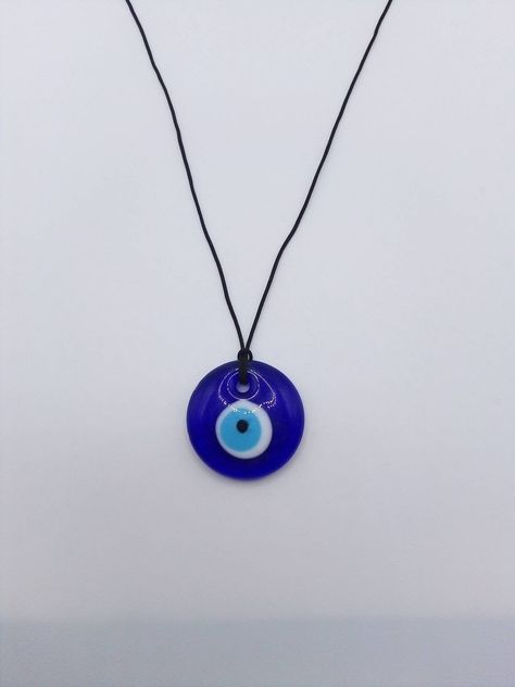 Big Evil eye choker necklace, Nylon String choker, Minimalist The evil eye is used to protect the person that wears it from the malevolent look of others who envy or dislike that person. The necklace is made with 1mm black nylon string,and has a 30mm blue glass evil eye bead. At the end it is adorned with seed beads. Total length: 80cm / 31 inches It is adjustable to fit a lot of sizes. Custom orders for different colour combinations are welcome. Other necklaces in my shop: https://www.etsy.com/ Talisman Car, Greek Eye, Witch Supplies, Protection Jewelry, Digital Closet, Amulet Necklace, Blue Evil Eye, Glass Pendant Necklace, Jewelry Lookbook