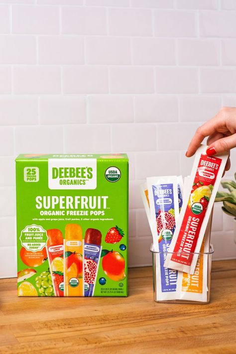 This image displays a box of DeeBee's Organics Classic SuperFruit Freezies and an acrylic box of DeeBee's Organics Classic SuperFruit Freezies tubes. There is a hand grabbing the strawberry lemon flavor. the flavors are strawberry lemon, blueberry pomegranate, and mango. Freezer Pops, Cream Packaging, Food Business Ideas, Ice Cream Packaging, Homemade Popsicles, Strawberry Lemon, Food Business, Grape Juice, Summer Refreshments