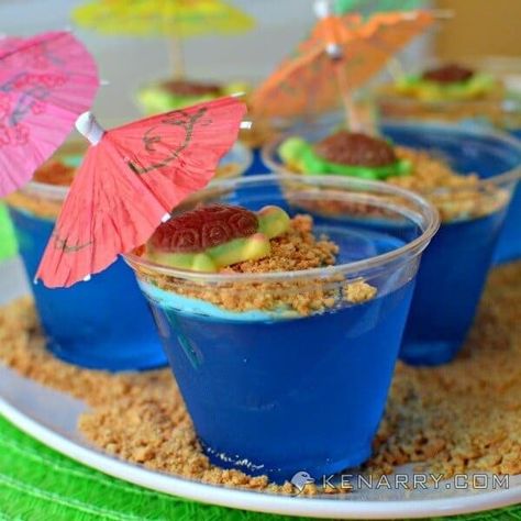 Tropical turtles on a sandy graham cracker beach in these cute and fun blue raspberry Jello cups for kids. They're a fun dessert idea for a summer parties. Jello Cups For Kids, Kids Luau, Tropical Turtle, Raspberry Jello, Lila Party, Jello Cups, Tropical Birthday Party, Island Party, Luau Theme Party