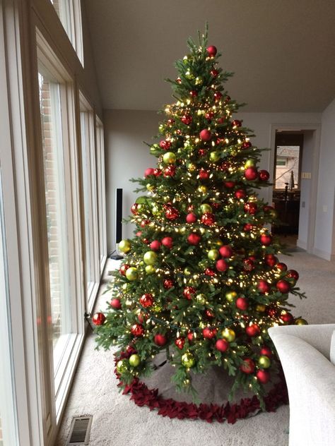 The tree is decorated with red and lime green ball ornaments, both matte and shiny, stuck with paper wrapped wire stems.  The ornaments are not hung from the tree branches in the traditional way. They are laid into and onto the tree as if they were a pick. The balls are next to weightless, so the stiff stems of the tree hold them up. Gold Red Green Christmas Tree, Red And Lime Green Christmas Tree, Christmas Decorations Red And Green, Red And Green Christmas Decorations, Green Red And Gold Christmas Tree, Red And Green Christmas Tree Decorations, Christmas Tree Ideas Red And Green, Green Red Christmas Decor, Christmas Decor Ideas Red And Green