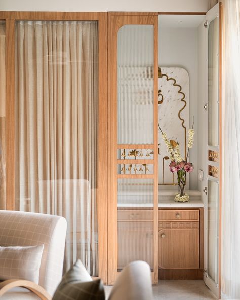 The mandir space of the Kābu home ❤️ When we brought down a bedroom wall to allow for more light in the living-dining spaces, we created a small space for the mandir. Minimal just like the rest of the home but warm and elegant , we conceptualised a marble back panel here with brass inlaid lotuses and religious motifs. A fluted glass door with strings of bells in a cutout in the middle, adds to the pious charm 🥰 . Photo credit: @nayansoni21 . . #studioipsa mandir | puja room | interior... Puja Room Interior Design, Small Puja Room Ideas, Studio Home Ideas, Small Pooja Room In Living Room, Small Mandir Design, Pooja Corner, Mandir Door Design, Mandir Unit, Mandir Design Puja Room