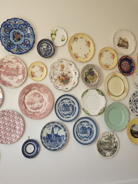 The vintage plates are all sourced from thrift stores.  Credit: Collette China Plate Gallery Wall, Decorative Plate Wall Display, Wall Of Plates Decor, Plates On Wall In Bedroom, Cute Plates Set, Vintage Plate Wall Decor, Thrift Decor Ideas Living Rooms, Cozy Thrifted Home, Plate Gallery Wall