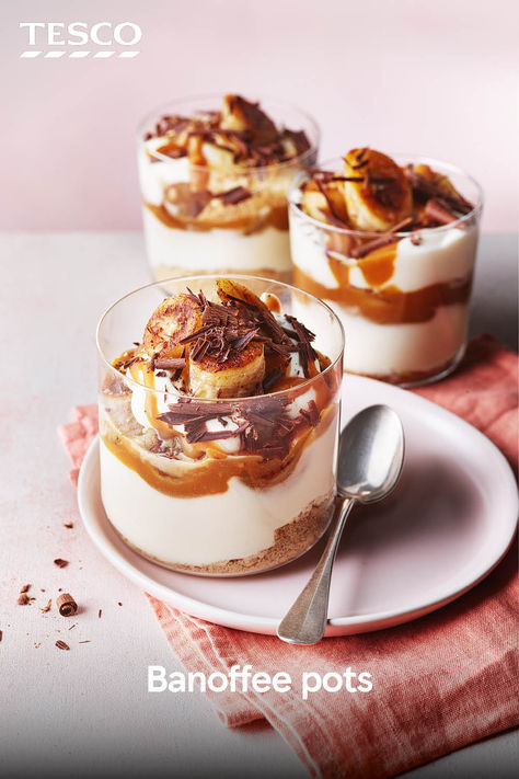 These banana trifle pots have big banoffee vibes. Top crumbled biscuits with whipped cream, caramel sauce, and sliced banana. They’re ready in just 20 minutes – perfect for when you’re craving something sweet. | Tesco Banoffee Parfait, Hygge Baking, Banoffee Trifle, Banoffee Pudding, Mini Trifle Desserts, Mini Trifles, Banana Trifle, Sweet Drinks Recipes, Banana Crumble