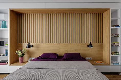 The design of this custom wall in a modern bedroom, combines wood and white details, and integrates the bed frame, a headboard, side tables, and bookshelves. #BedroomDesign #ModernBedroom #Headboard #Bookshelves Mattress Room, Headboard With Shelves, Built In Bed, Stylish Apartment, Slatted Headboard, Headboard Wall, Lighting Design Interior, Bedroom Headboard, Wood Bedroom