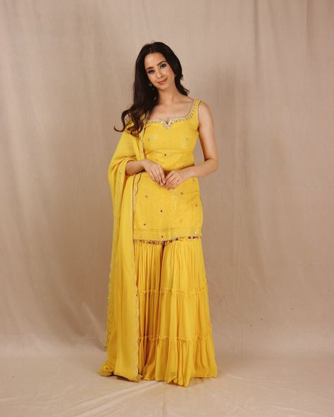 Introducing “Genda Phool”. The perfect sunshine yellow color to wear on your BFF’s Haldi. This stunning yellow kurta is crafted from crepe georgette with a luxurious 3-layered sharara. Adorned with intricate handwoven mirrors on the neckline and throughout the shirt, it features a beautifully handworked dupatta with colored tassels for a perfect finish. Shop our collection now. DM or email to book an appointment. #haldioutfit #haldidress #yellowsuit #shararadesign #shararasuits #shararad... Yellow Organza Sharara, Haldi Ceremony Outfit For Women, Yellow Dress For Haldi Function Pakistani, Yellow Kurta Woman, Simple Yellow Dress For Haldi Function, Yellow Kurti Design For Haldi, Yellow Sharara For Haldi, Yellow Dress For Haldi Function, Haldi Outfits For Sister