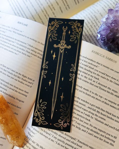 Some of you may have seen my story last week ✨ well here’s a look into the most gorgeous bookmarks that I designed 🗡️ there are three bookmark designs, two are gold foil and one is holographic foil. I’m absolutely floored with how stunning these are! They will be available on the 30th at noon! 💫🖤 #bookish #acotar #throneofglass Gold Foil Bookmarks, Art Bookmark Ideas, Drawing Bookmarks Ideas, Bookmarks Diy Aesthetic, Bookmark Design Printables, Acotar Bookmarks, Book Marks Design Ideas, Cricut Bookmarks, Bookmark Design Ideas