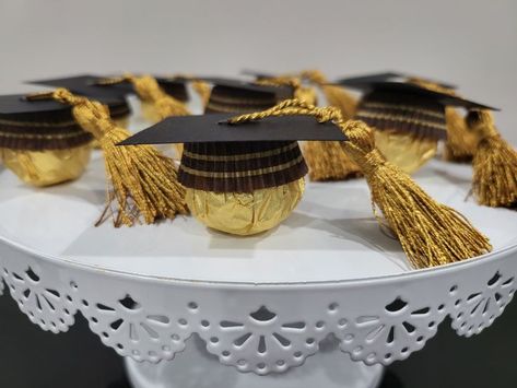 We created these cute graduation themed party favors for an upcoming graduation celebration this weekend using Ferrero Rocher Chocolates, black cardboard paper and miniature gold tassels.  

They are easy to make, something that the kids can get involved in and a hit with your guests.  I mean who doesn't like a chocolate treat or two?  #rocher #ferrero #chocolate #graduation #partyfavors Chocolate Graduation, Ferrero Rocher Chocolates, Graduation Party Diy, Graduation Party Favors, Ferrero Rocher, Graduation Celebration, Cardboard Paper, Chocolate Treats, Themed Party