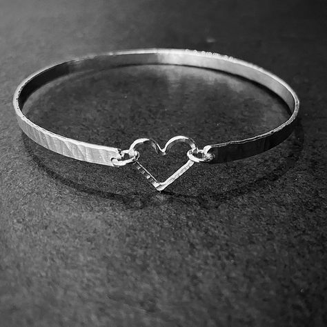 Handmade in my workshop in Fife Scotland this handmade silver bangle is simple and elegant, each bangle is unique, rolled and textured silver wire is formed and linked with an open silver heart. It is perfect for everyday wear as it is light and comfortable, it can also be worn along with other bangles from the same collection. It would make a perfect gift for a lady of any age. Comes in 3 sizes, small 6cm inside diameter, standard 6.5cm or large 7cm. Unless specified otherwise it will be made in standard size. Free gift wrapping and personalised gift card available on request Silver Heart Nails, Heart Bangle Bracelet, Fife Scotland, Sparkly Bracelets, Hammered Bangles, Handmade Silver Jewellery, The Bangles, Silver Bracelets For Women, Diy Wire Jewelry