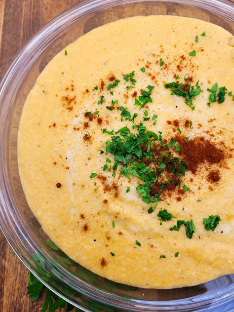 A bowl of smoked gouda cheese grits garnished with parsley and smoked paprika. Smoked Gouda Polenta, Steak Bites Over Creamy Gouda Grits, Smoked Gouda Cheese Grits, Smoked Guada Grits, Green Chili Grits, Shrimp And Gouda Cheese Grits Recipe, Best Cheese Grits Recipe, City Grits Recipe, Quick Grits Recipe