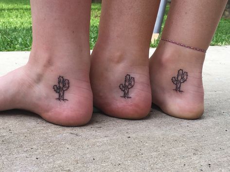 3 women’s inner ankles. There is a  saguaro cactus with some spines on it, with a line as the dirt and a couple small pebbles beneath. Small Western Ankle Tattoo, Prickly Pear Cactus Tattoo Small, Cactus Tattoo Ankle, Western Sibling Tattoos, Dainty Cactus Tattoo, Matching Cactus Tattoos, Nopales Tattoo, Inner Foot Tattoo, Small Arizona Tattoo