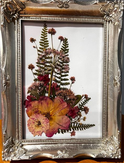 "Pressed Flower Art: Pressed roses, ferns and delicate pink wild flowers displayed in an artistic spray on a white background.  Silver painted, 7\"x9\" frame is free-standing or ready to hang on a wall" Press Flower Art, Pressed Leaf Art, Pressed Flower Art Picture Frames, Diy Pressed Flower Art, Framed Dried Flowers, Pink Wild Flowers, Framed Pressed Flowers, Pressed Roses, Dried Flowers Crafts