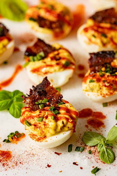 Deviled eggs with spicy sriracha drizzle, paprika, and candied bacon on top! Brunch Deviled Eggs, Cajun Deviled Eggs, Spicy Deviled Eggs Recipe, Decorated Food, Eggs Deviled, Smoked Deviled Eggs, Easter Appetizers Easy, Devil Eggs, Perfect Deviled Eggs