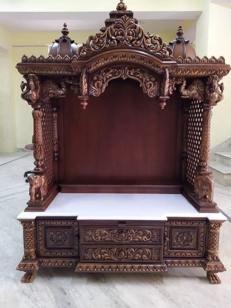 This beautiful and Carved Wooden Home Temple has been crafted from the finest quality of wood and designed with intricate delicate details that will bring peace and spirituality to your home. The Traditional carved altar features a large drawer with an intricately carved image of an elephant symbolizing sacredness, stability, and strength. - DIMENSIONS: External Size: Height: 60" inches Approx. Width: 40" inches Approx. Depth: 18" inches Approx. *The deep hues of this Wooden Temple The Wooden Te Wooden Temple For Home, Pooja Ghar, Wooden Temple, Mandir Design, Temple Design For Home, Pooja Mandir, Indian Temple, Home Temple, Temple Design