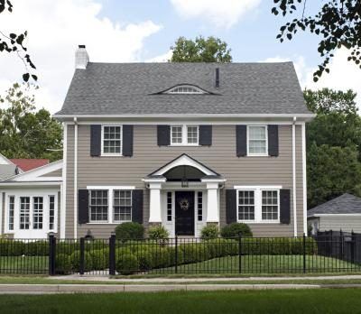 One way to tie in your exterior walls with a grey roof is to paint them a different shade of grey Colonial Remodel, Tan House, Colonial House Exteriors, Best Exterior Paint, House Paint Color Combination, Black Shutters, House Shutters, Gray House, Exterior House Color