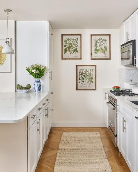 White galley style kitchen designed with herringbone wood floors, a jute rug, and vintage botanic wall prints. Mismatched Furniture, Galley Kitchen Design, Herringbone Wood Floor, Herringbone Wood, Galley Style Kitchen, Striped Walls, White Kitchen Design, Galley Kitchen, Transitional Kitchen