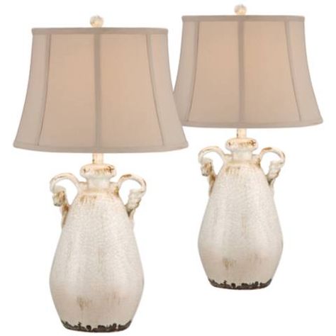 A romantic country tone resonates in this set of two charming crackled ivory table lamps. Set of 2 lamps. Each is 28" high. Bases are 12" wide in the middle x 6" wide at the bottom. Shades are 12" across the top x 16" across the bottom x 10 1/2" high. Each uses one maximum 150 watt standard base bulb (not included). On-off switch on socket. 8-foot long brown cords. Style # 2W497-2W497 at Lamps Plus. Country Cottage Table, Farmhouse Style Lighting Fixtures, Rustic Country Cottage, Farmhouse Floor Lamps, Country Lamps, Farmhouse Style Lighting, Cottage Table, Farmhouse Table Lamps, Farmhouse Lamps