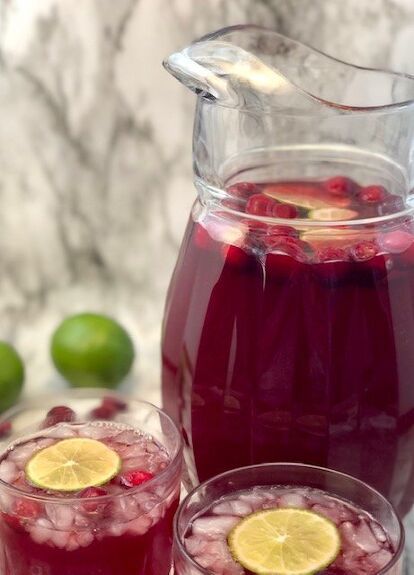 Cranberry Limeade makes a very pretty punch for Christmas. Cranberry and lime go so well together.One of my favorite soft drinks is Sonic’s Cranberry Limeade. We tried to recreate that taste for a pretty holiday beverage. Of course, I love to go get this drink during happy hour when it is half price, too! Check out our many other recipes on Sweeter With Sugar. Happy Holidays! Serve Cranberry Limeade in a pretty pitcher or in a pretty drink dispenser. Also serve with straws for those… Cranberry Limeade, Punch For Christmas, Limeade Punch, Cranberry Lemonade, Pretty Punch, Christmas Cranberry, Limeade Recipe, Cranberry Drinks, Frozen Limeade