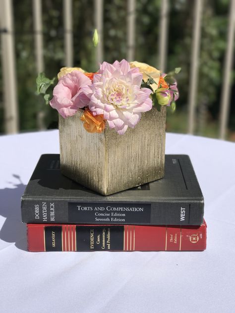 Law school graduation centerpieces - add the flowers to a stack of textbooks to incorporate the theme and provide some height to the centerpiece Law School Graduation Centerpieces, Law Centerpieces, Law School Graduation Party Centerpieces, Law School Graduation Party Ideas Lawyer, Graduation Party Ideas Law School, Law School Graduation Party Decorations, Graduate Party Ideas, Law Graduation Party Ideas, Law School Graduation Party Ideas