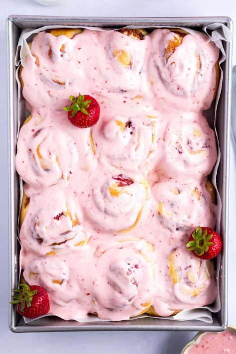 Fruity strawberry cinnamon rolls are a fun twist on the classic breakfast treat. Made with a quick and easy homemade jam filling and a pretty pink strawberry cream cheese icing. Strawberry Jam Cinnamon Rolls, Strawberry Winter Rolls, Strawberry Rolls Recipe, Strawberries And Cream Cinnamon Rolls, Strawberry Rolls With Cream Cheese Icing, Fun Cinnamon Roll Ideas, Valentines Cinnamon Rolls, Flavored Cinnamon Rolls Homemade, Strawberry Cream Cheese Recipes