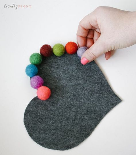 DIY Felt Ball Heart Trivet. A beautiful handmade gift idea for someone you love that's perfect for Mother's day. Learn how to make this easy Hometalk DIY project to give as a homemade Mother's Day gift. Pretty and functional, this easy DIY craft project idea for a heart shaped trivet will look adorable in Mom's kitchen! All you need for this kitchen craft project is a glue gun, some thread, felt and a rainbow of pom pom balls in bright colors. How to make a whimsical trivet for DIY gifts. Felt Ball Crafts, Valentines Tea Party, Tovad Ull, Valentine Tea, Easy Homemade Gifts, Diy Blanket Ladder, Felt Balls, Diy Felt, Simple Valentine