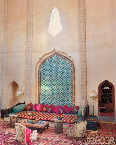 A luxurious overscale banquette in the three-story living room of nightclub impresario Jaouad Kadiri’s  Marrakech house is anchored by Uzbek-inspired tilework; the  pillows are covered in sari silks, and the English-style armchairs are upholstered in vintage Persian rugs. (February/March 2002)   - ELLEDecor.com Dekorasi Maroko, Moroccan Interior Design, Moroccan Style Interior, Moroccan Inspiration, Moroccan Living Room, Moroccan Interiors, Bohemian Living, Makeup Room, Moroccan Design