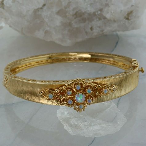 Retro Style 14K Yellow Gold Crystal Opal Hinged Bangle Bracelet, 4 mm central opal, 9 fine round cabochons with blue, green and yellow fire, stones are prong set, pierced decoration, florentine finish with polished areas to locking box clasp, 5/8 inch across, 9/16 inch high at center, Circa 1950, 24.4 grams Stock # BB555B03 This listing contains photographs of the actual item you will receive. Our items are in excellent condition with little or no signs of wear and many are one of a kind pre-own Gold Snake Jewelry, Vintage Gold Bracelet, Gold Jewelry Set, Dope Jewelry Accessories, Yellow Jewelry, Crystal Opal, Dope Jewelry, Box Clasp, Jewelry Lookbook