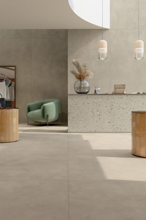 Multiforme Dune is a concrete and resin-inspired porcelain stoneware tile collection by Marca Corona. Its large format tile variants are highly versatile not only for residential spaces but also for commercial ones. Covering the walls and floor of a fashion store, the Fossile version creates a cool-toned neutral ambiance. Arkistyle Shade Cold lines the side of the counter and adds character to the room with an eye-catching Terrazzo-inspired pattern. Tiles Living Room, Concrete Terrazzo, Terrazzo Tile, Terrazzo Tiles, Large Tile, Large Format Tile, Italian Tiles, Corner House, Concrete Tiles