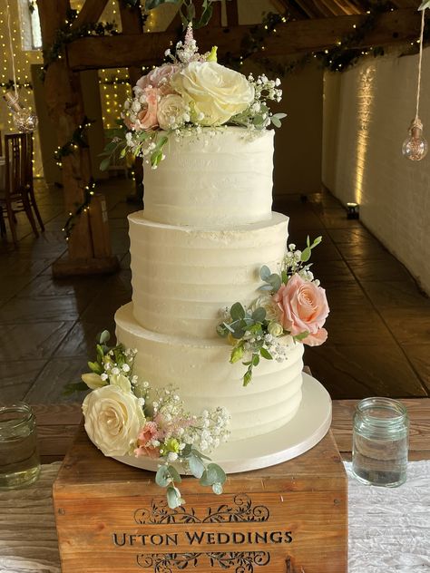 3 tier buttercream frosted wedding cake with fresh flowers including roses, lisianthus, gypsophilia and eucalyptus Fake Flowers On Wedding Cake, 3 Tier Buttercream Wedding Cake, Wedding Cake 3 Tier Flowers, 3 Tier Wedding Cake With Flowers, Cakes With Real Flowers, Wedding Cake Fondant Flowers, Wedding Cake Decorations Flowers, Frosted Wedding Cake, Wedding Cake With Fresh Flowers