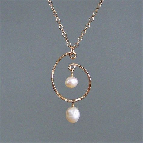 "A simple and elegant pendant. Two freshwater pearls are suspended from an elliptical ring (1.25\") which is hand-forged and hammered - a sturdy and heavy gauge wire. This pendant is secured with a \"J\" hook and has a 3\" extender Available in bright & oxidized sterling and 14K goldfill" Pendant Jewelry Diy, Silver Wire Jewelry Diy, Wire Beads Jewelry, Jewelry Patterns Gold, Modern Pearl Necklace Design, Making Beaded Jewelry, Metal Jewelry Handmade, Handmade Pearl Jewelry, Wire Wrapped Jewelry Diy