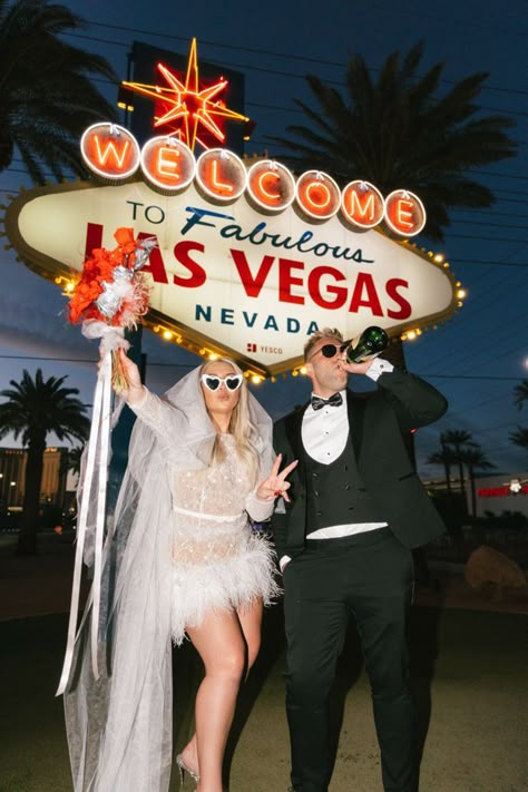 After the drive-through ceremony, their adventure took them to the iconic Las Vegas sign, where they immortalized their big day with portraits. | Image by Erin Roberts Showpo Wedding Dress, Vegas Wedding Accessories, Fun Vegas Elopement, Elvis Wedding Dress, Vegas Inspired Wedding Dress, Vegas Wedding Veil, Old Vegas Engagement Photos, Retro Las Vegas Wedding, Las Vegas Themed Wedding Reception