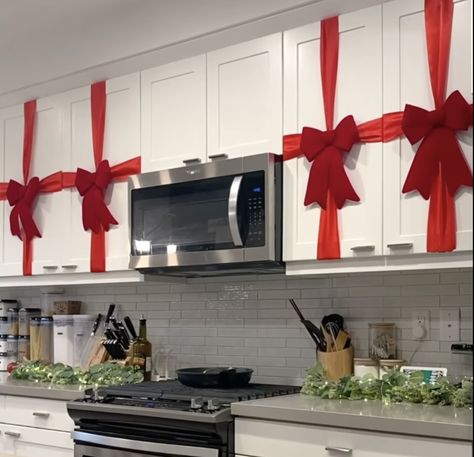 Decorating your kitchen for Christmas 🎄 Red Bow On Kitchen Cabinets, Red Ribbon On Kitchen Cabinets, Christmas Decoration Kitchen Cabinets, Kitchen Cabinet Ribbon Christmas, Cabnit Christmas Bow, Christmas Decor Small Kitchen, Christmas Home Decor Kitchen, Christmas Decor Ideas Renter Friendly, Brown Cabinet Christmas Decor