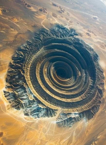 Richat Structure, the "Eye of the Sahara" The Richat Structure, also known as the "Eye of the Sahara," is a prominent circular geological formation located in the Sahara Desert in Mauritania. This distinctive feature, visible from space, resembles a large bull's-eye and is about 40 kilometers (25 miles) in diameter. Initially thought to be an impact crater, it is now believed to be a highly eroded dome of sedimentary rock. The concentric rings of the Richat Structure make it a fascinating su... Eye Of The Sahara, Impact Crater, The Sahara Desert, David Attenborough, Sedimentary Rocks, Sahara Desert, Rock Formations, Rock Crystal, Landscape Photos