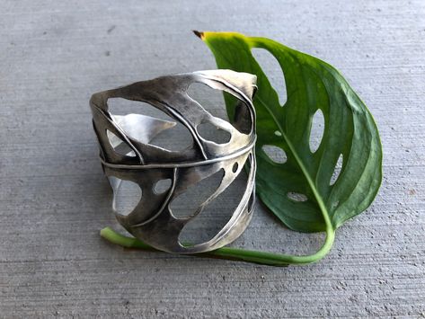 This Monstera Swiss Cheese cuff is hand fabricated with sterling silver sheet and wire. Formed using the heat of my torch, stakes and hammers. It is 2.5" at its widest point and 6" (not including the gap) around.This piece is one of a kind. Sheet Metal Jewelry, Unique Jewelry Inspiration, Nature Inspired Jewelry Sterling Silver, Jewellery Inspiration, Dope Jewelry, Swiss Cheese, Funky Jewelry, Nature Inspired Jewelry, Jewelry Lookbook