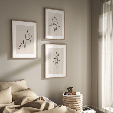 An irresistible trio of neutral wall art prints, perfect for your minimalist interior. This set of three beige wall prints features line drawings of females effortlessly posing. The nude drawings add a touch of cheekiness whilst remaining classy. Try hanging this wall art set in your living room either side by side or on top of each other to add an elegant touch to your home décor. Three Frames Above Bed, Picture Wall Over Bed, Three Pictures On Wall Layout, Side Of Bed Wall Decor, Bedroom Wall Prints Above Bed, Three Picture Frames On The Wall, Photos For Bedroom Wall, Pictures In Bedroom Ideas, Three Frames On Wall