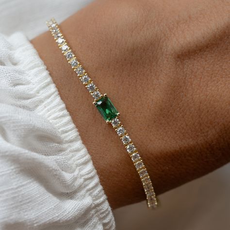 Super chic tennis bracelet with an emerald baguette charm, that is beautiful and elegant! Adds a nice touch of sparkle! Looks like real diamonds! We use a Thick plating of 14k Gold or Rhodium over brass Available in Sizes: 6.5" or 7" 2mm Thickness 4x6mm Baguette Stone Latch Closure Nickel-free, lead free and hypoallergenic Highest Grade CZ for an authentic diamond look Available in Diamond, Sapphire, or Ruby Jewellery Wardrobe, Emerald Bracelet, Sapphire Bracelet, Ruby Jewelry, Tennis Bracelet Diamond, Diamond Jewellery, Jewelry Inspo, Green Grass, Exquisite Jewelry