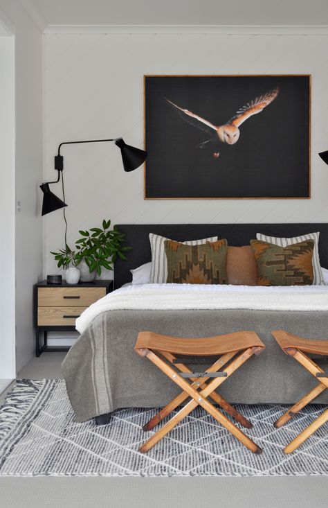 With a subtle military theme in this men's bedroom in the campaign stools, army style blanket and the khaki kilim cushions, it all comes together in a subtle way. With a modern black wall lamp, the impressive large scale owl wall art and peel-and-stick canvas wallpaper, black bedhead and grey rug, it comes together well. Check out the full masculine bedroom makeover by clicking on the pin. Bedroom Masculine, Bedroom Upgrades, Masculine Room, Man Bedroom, Bedroom Ideas For Men, Frame Tutorial, Mens Bedroom Decor, Diy Interior Decor, Masculine Bedroom