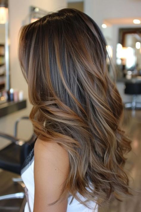 Woman with long, wavy hair featuring a brown balayage hairstyle in a modern salon. Shoulder Length Dark Hair With Highlights, Dark Brown Hair W Highlights, Long Hair Brown Balayage, Brunette Hair Lowlights, Medium Length Haircut Brown Hair, Winter Balayage Brunettes, Brunette Hair Medium, Dimensional Brunette Highlights, Light Brown Balayage On Dark Hair