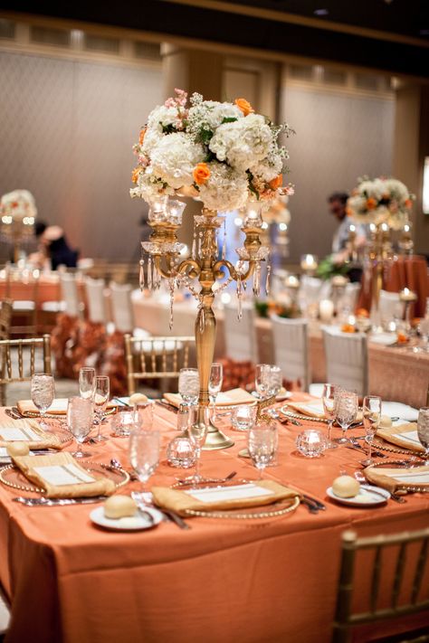 Tall gold centerpiece with orange and peach flowers Some Like It Classic Wedding Design - somelikeitclassic.com  Photography: Bridgette Marie Photography - www.bridgettemarie.com  Read More: http://www.stylemepretty.com/2014/08/12/glamorous-orange-gold-wedding/ Orange Gold Wedding Theme, Brown And Peach Wedding, Orange And Gold Wedding Theme, Orange And Gold Wedding, Orange Gold Wedding, Orange Quinceanera, Ramadhan Decor, Peach And Gold Wedding, Peach Wedding Centerpieces