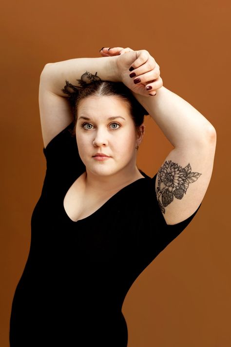 A woman poses with her hands above her head in front of an orange backgroundfor her studio headshot Hands Above Head Pose Reference, Hands Above Head Pose, Hands Behind Head Pose, Hands Above Head, Head Pose, Studio Headshots, Pulled Back Hairstyles, Hair Pulling, Wnba