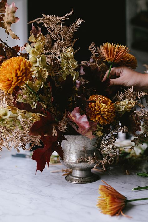 Learn How to Make this Modern Thanksgiving Centerpiece with Dried Flowers, Golden Chrysanthemums, Cream Spray Roses, Branches of oak and maple leaves. Get the full DIY tutorial on Jojotastic.com #flowerarrangement #floralarrangement #flowerarranging #centerpiece #thanksgiving #fall #thanksgivingdecor #florals #flowers #fallflowers #friendsgiving Thanksgiving Flowers Centerpieces, Fall Ikebana Arrangements, Diy Thanksgiving Decorations Table, Thanksgiving Floral Centerpieces, Moody Thanksgiving, Thanksgiving Arrangements, Thanksgiving Flower Arrangements, Thanksgiving Floral Arrangements, Thanksgiving Centerpieces Diy