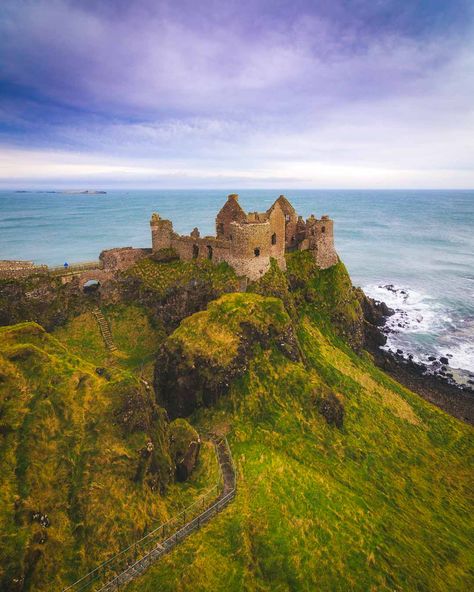 Northern Ireland travel. Dunluce Castle, Northern Ireland – Epic Medieval Castle on the Cliffs - Dunluce Castle is a castle in Northern Ireland, built on top of cliffs, and connected to mainland by a small bridge. It even has a massive cave underneath! #ireland #irelandtravel #travelguide #cityscape #castle #europetravel #travelguide #gameofthrones #traveldestinations Northern Ireland Itinerary, Antrim Ireland, Dunluce Castle, Northern Ireland Travel, Ireland History, Ireland Road Trip, Ireland Photography, Castles In Ireland, Ireland Landscape