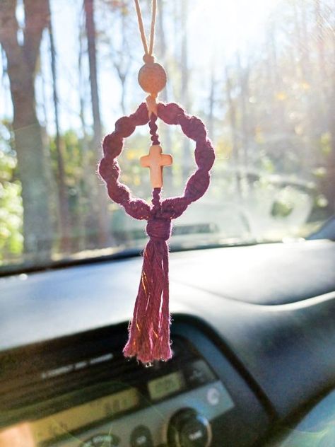 Rearview mirror car cross. Lava bead car hanger cross.  Bring a little joy to your family and friends with this unique gift. Great for Bible study group, family, friends, and coworkers.  Also, it can be used as a rear-view mirror car charm. The lava bead serves as a diffuser. Just add a few drops  of your favorite essential oil to the bead and enjoy.  * Ornament * Lava bead car diffuser  * Semiprecious cross bead * Made to order Colors: Peacock Blue Mustard Yellow Burnt Orange Gold Blueberry (Purple with white cross) * Gold Blueberry features a gold strand in the cord.  Also available without the gold strand, just choose the Blueberry option.  * Free shipping  on orders over $35 This cute Macrame diffuser is created with macrame  cord, lava bead, and semiprecious cross bead. If used as a c Cross Decorations, Recuerdos Primera Comunion Ideas, Car Hanging Accessories, Car Mirror Hangers, Mirror Car Accessories, Birthday Room Decorations, Diy Earrings Easy, Purple Car, Car Hangers