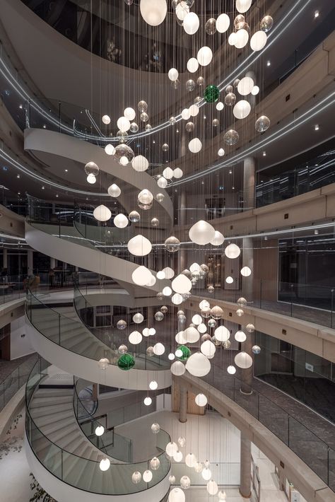 An interactive lighting installation that sparkles and surprises. 🌟 This bespoke Preciosa Lighting installation consist of 226 hand-blown crystal spheres representing the bank’s branches. ✨ We used modern technologies as a welcome and a thank you to employees and customers. 🤍 What do you think about the atrium of Credit Agricole’s regional headquarters in Clermont-Ferrand, France? Atrium Chandelier, Atrium Lighting, Hotel Penthouse, Interactive Lighting, Atrium Design, Orb Light, Lighting Installation, Large Pendant Lighting, Clermont Ferrand