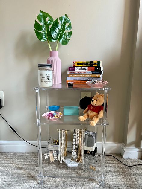 I wanted furniture and home decor that made my apartment feel open/airy. I am obsessed with the acrylic aesthetic and wanted a small, cute table in my bedroom to display some of my books and jewelry. This 3-tier clear end table is from Amazon. #acrylic #nightstand #jewelry #livingroomfurniture #bedroomdecoration #bookcase #organizer #poohbear Small Bedside Table Ideas, Acrylic Nightstand, Acrylic Aesthetic, Acrylic Side Table, Small Bedside, Office Hallway, Small Bedside Table, Table For Living Room, Hallway Bedroom