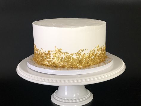 Watch this video to see how you too can make this elelgant white and gold cake! White Cake Gold Flakes, White Cake Gold Sprinkles, Simple Wedding Cake White And Gold, Gold Fleck Cake, White And Gold Birthday Cake For Men, White And Gold 40th Birthday Cake, Gold White Cake Birthday, White Cake With Gold Accents, White And Gold Smash Cake