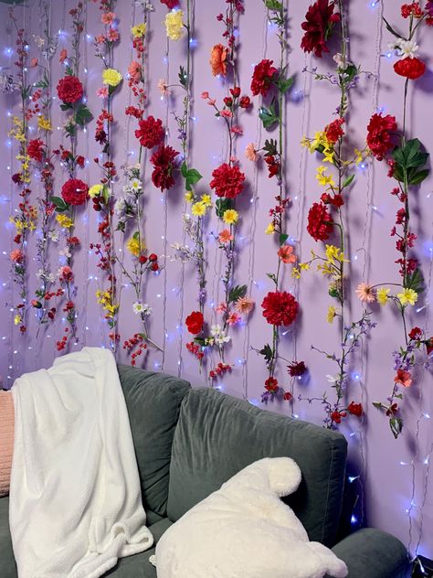 DIY flower wall with fairy lights behind a loveseat. Perfect zoom background in a home office Flower Wall With Lights, Home Office Backdrop Flower, Flower Themed Living Room, Hanging Flower Wall With Lights, Fairy Light And Flower Wall, Led Light On Flower Wall, Flower Wall Room, Fairy Office Decor, Fairy Lights Bedroom Flowers